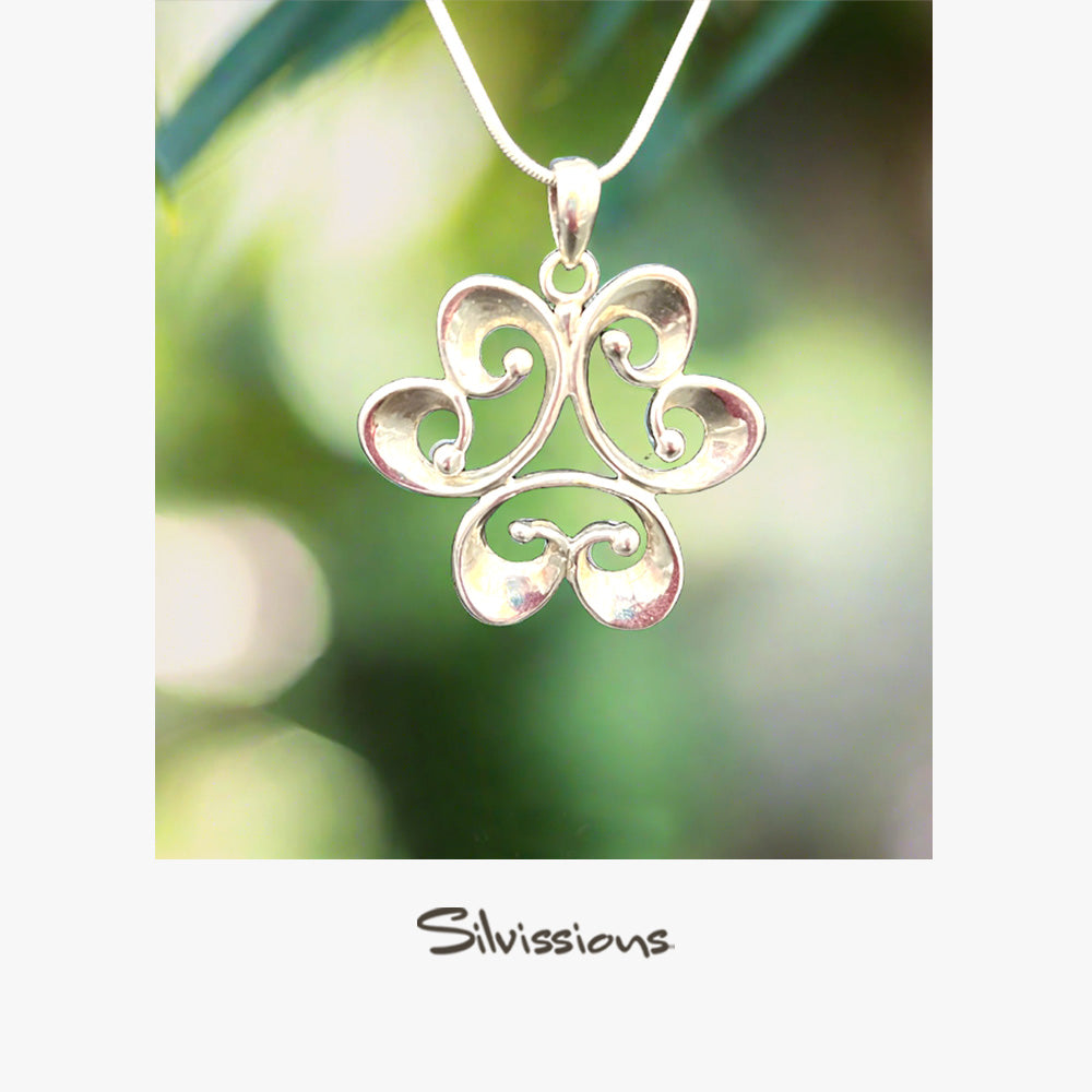 Silver filigree pendant on a blurred green background with 'Silvissions' branding.