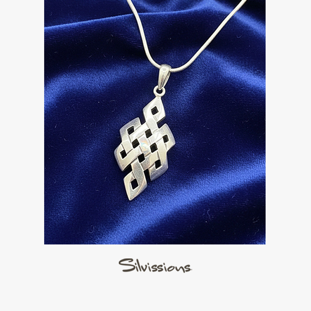Silver necklace with a geometric pendant on a blue satin background, branded 'Silvissions'.