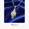 Silver necklace with a geometric pendant on a blue satin background, branded 'Silvissions'.