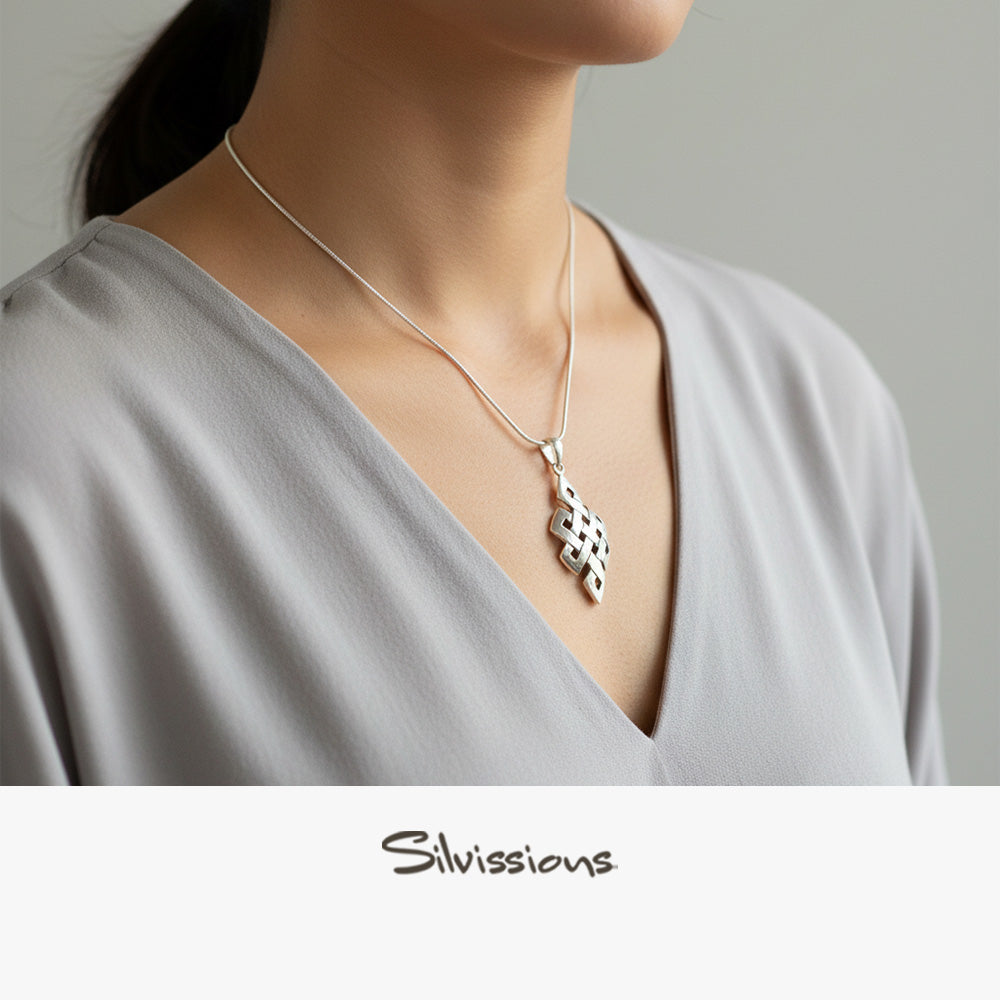 Silver necklace with a pendant worn by a person in a gray top, brand 'Silvissions' visible.
