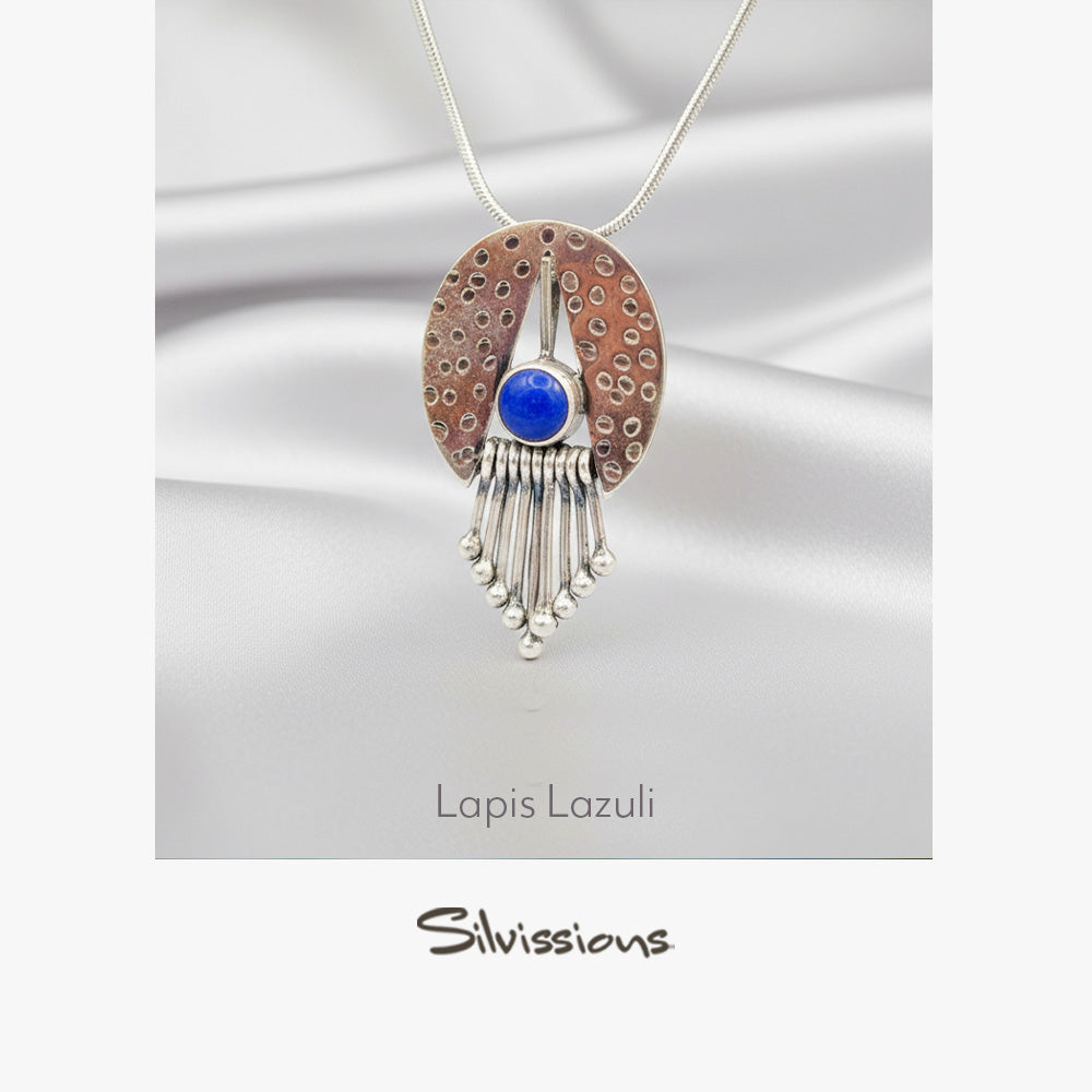 Jewelry pendant with blue stone and silver fringe on a white background, featuring the brand 'Silvissions'.