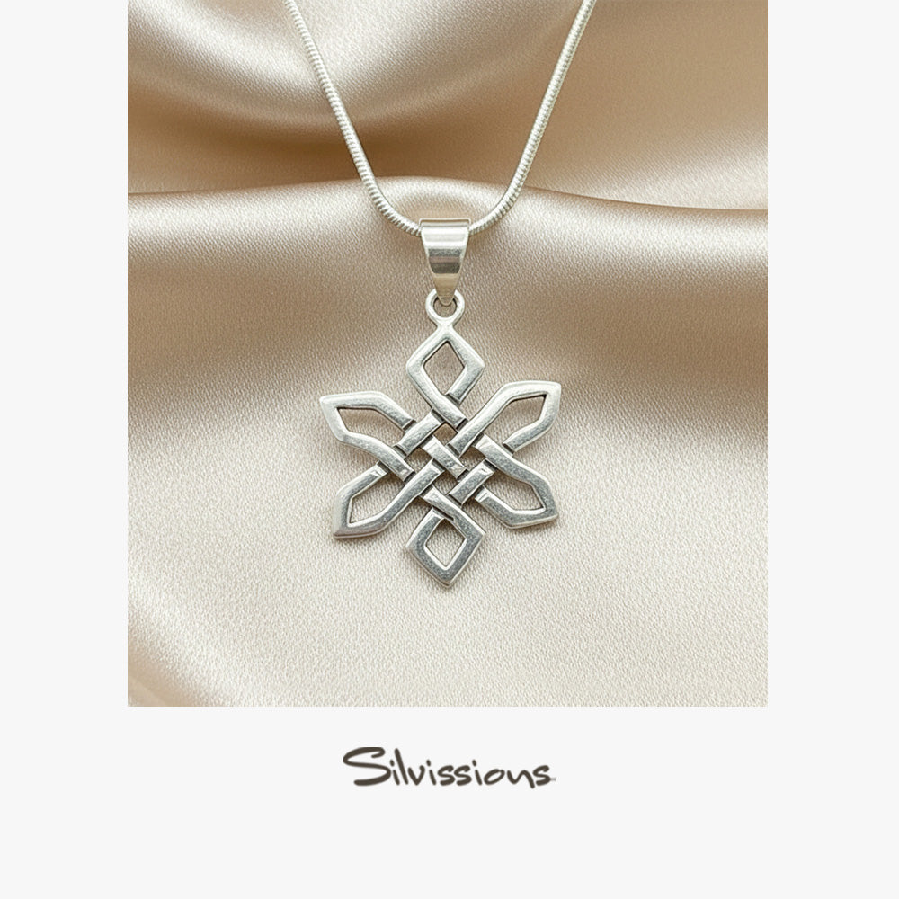 Silver necklace with a intricate pendant on a beige satin background, featuring the Silvissions Jewelry brand.
