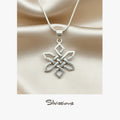 Silver necklace with a intricate pendant on a beige satin background, featuring the Silvissions Jewelry brand.