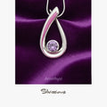 Silver pendant with a purple gemstone on a purple satin background, featuring the brand 'Silvissions'.
