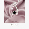 Silver pendant with black onyx stone on pink satin fabric, featuring the brand 'Silvissions'.