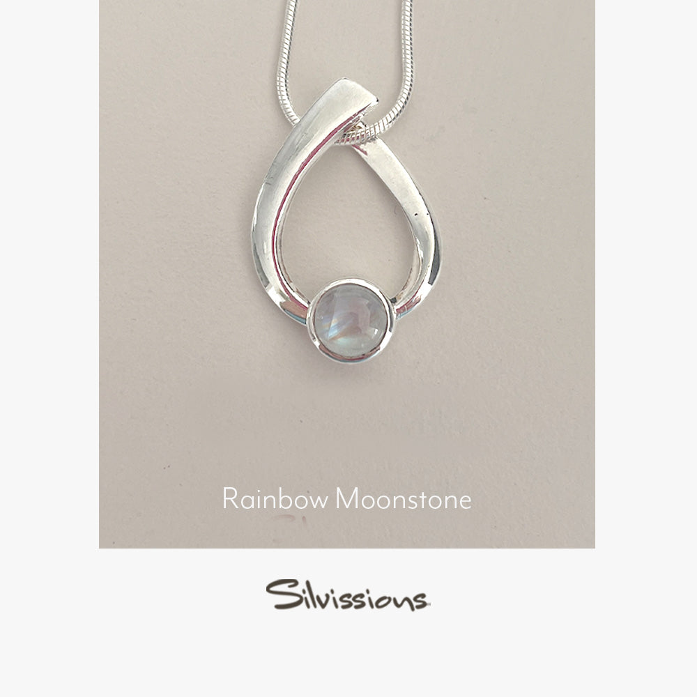 Silver pendant with rainbow moonstone on a beige card, featuring the brand 'Silvissions'.