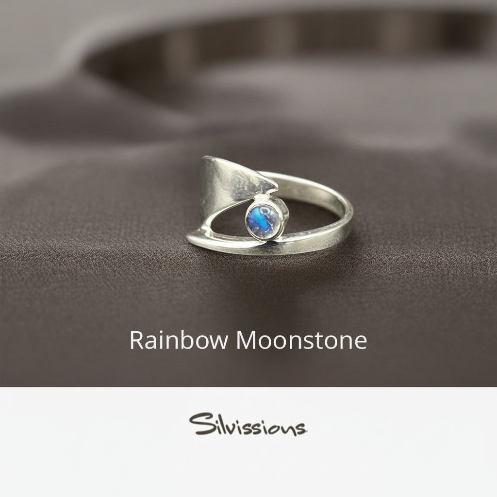 Silver ring with a rainbow moonstone on a neutral background, featuring the brand 'Silvissions'.