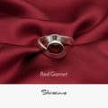Silver ring with a red gemstone on red fabric, featuring the brand 'Silvissions'.