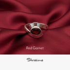 Silver ring with a red gemstone on red fabric, featuring the brand 'Silvissions'.
