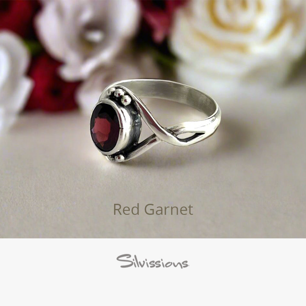 Silver ring with red gemstone on a neutral background, featuring the brand 'Silvissions'.