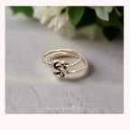 Silver knot ring on a light background with 'Silvissions' branding
