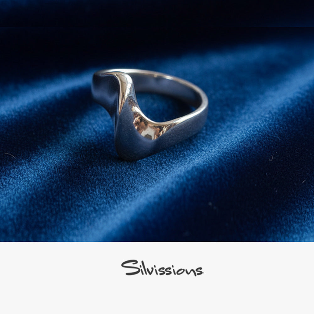 Silver ring on blue fabric with 'Silvissions' branding
