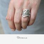 Silver ring on a finger with 'Silvissions' branding