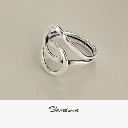 A sterling silver ring with an intricate endless knot design, displayed on a light background with a text mentioning the artisan jewelry crafted with genuine sterling silver and gemstones.