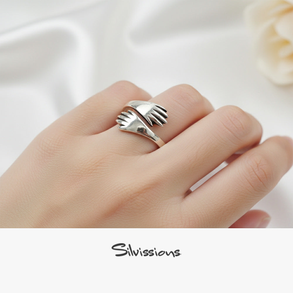 Silver ring on a finger with 'Silvissions' branding
