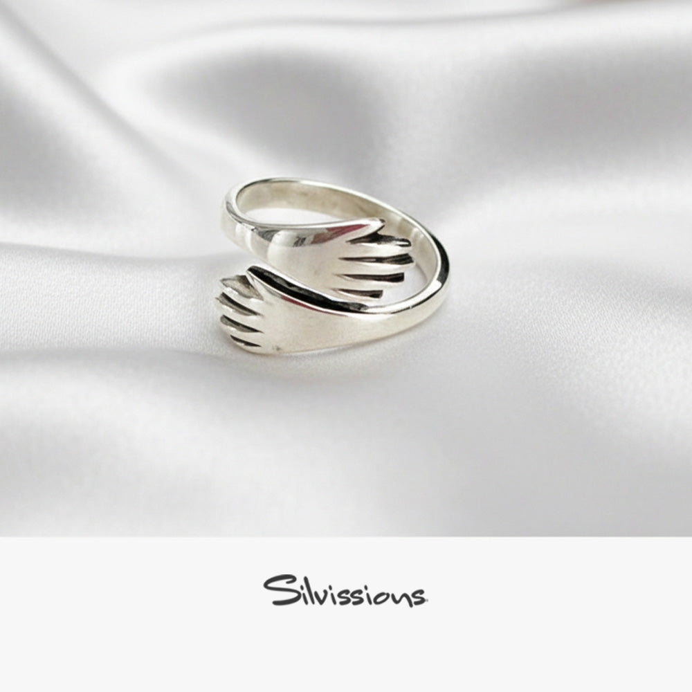 Silver hand-shaped ring on a white satin background with 'Silvissions' branding.