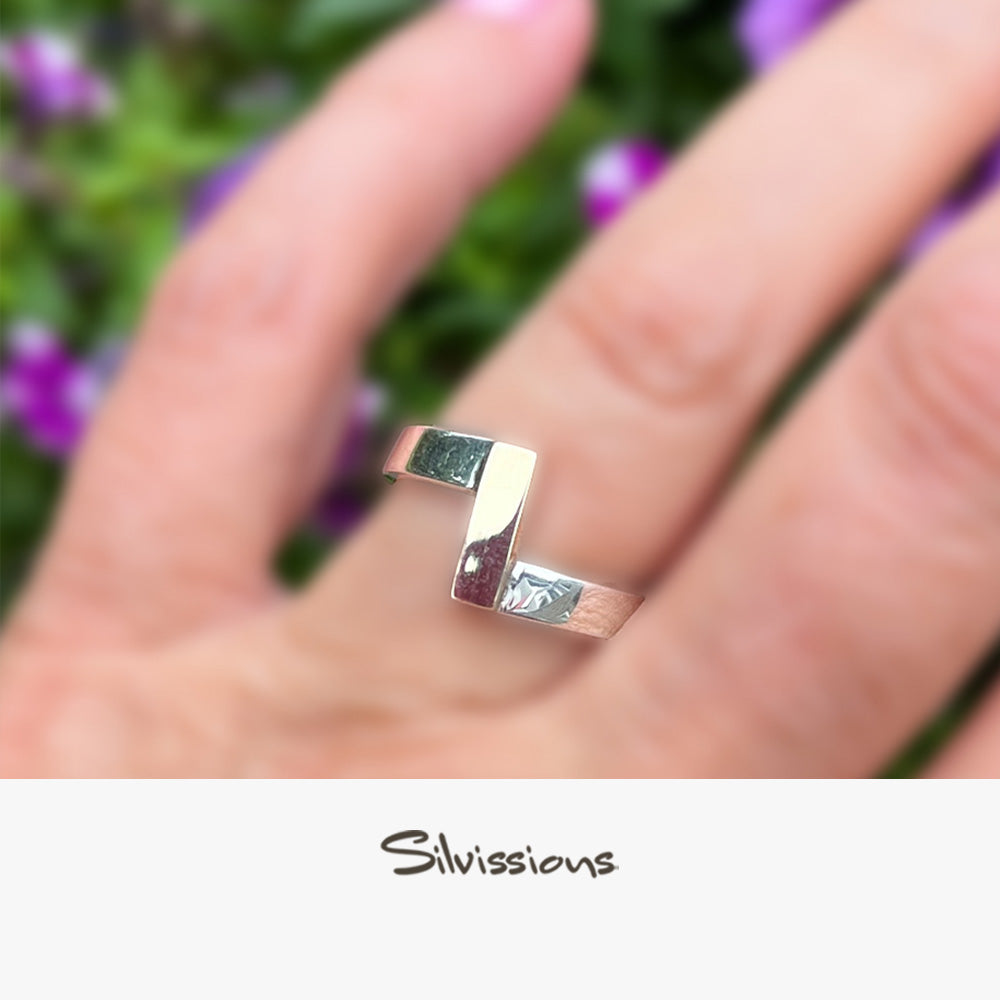 Silver ring on a finger with a blurred natural background