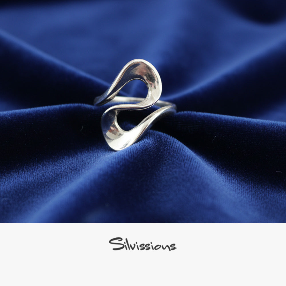 Silver ring on blue fabric with 'Silvissions' branding