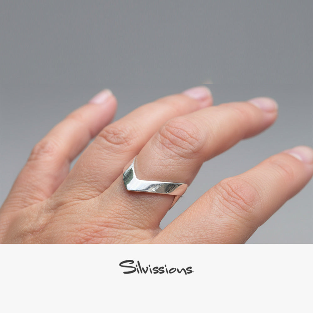 Silver ring on a finger with 'Silvissions' branding