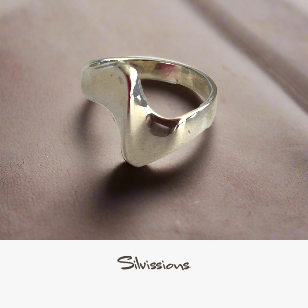 Silver ring on a beige fabric background with 'Silvissions' branding.