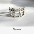 Silver ring with a design of four family members holding hands on a light gray background, branded 'Silvissions'.