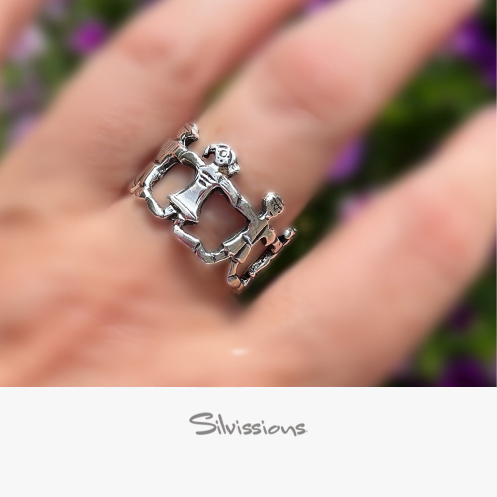 A sterling silver ring with a design that resembles a family unit, featuring a man, woman, and a son and daughter located on a finger.