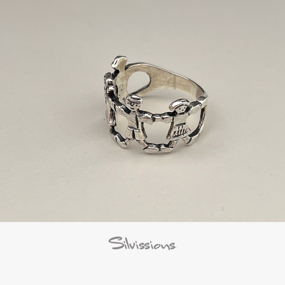 Silver ring with intricate family design on a light gray background, branded 'Silvissions'.