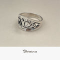 Silver ring with intricate design on a beige background, branded 'Silvissions'.