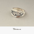 Silver ring with intricate design on a light gray background, branded 'Silvissions'.