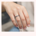 Silver ring on a finger with 'Silvissions' branding