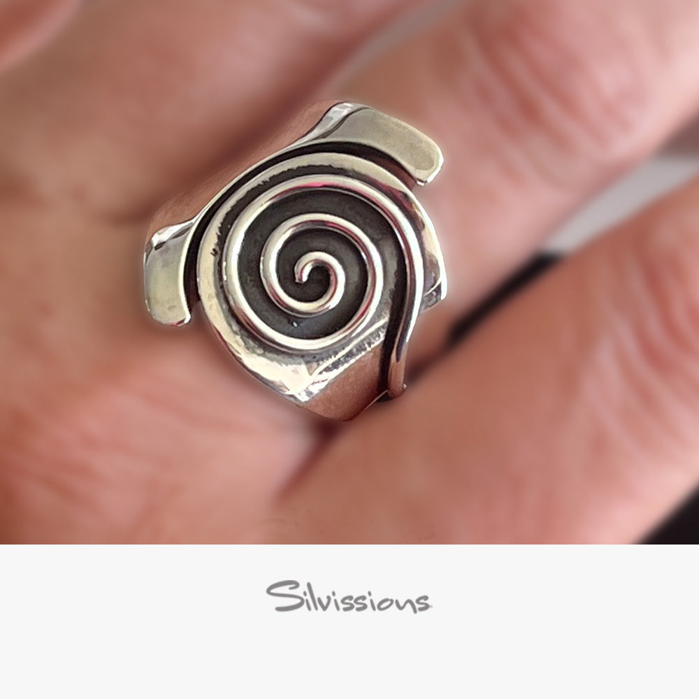 Silver spiral ring on a finger with 'Silvissions' branding.