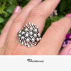 Silver ring on a hand with a blurred natural background