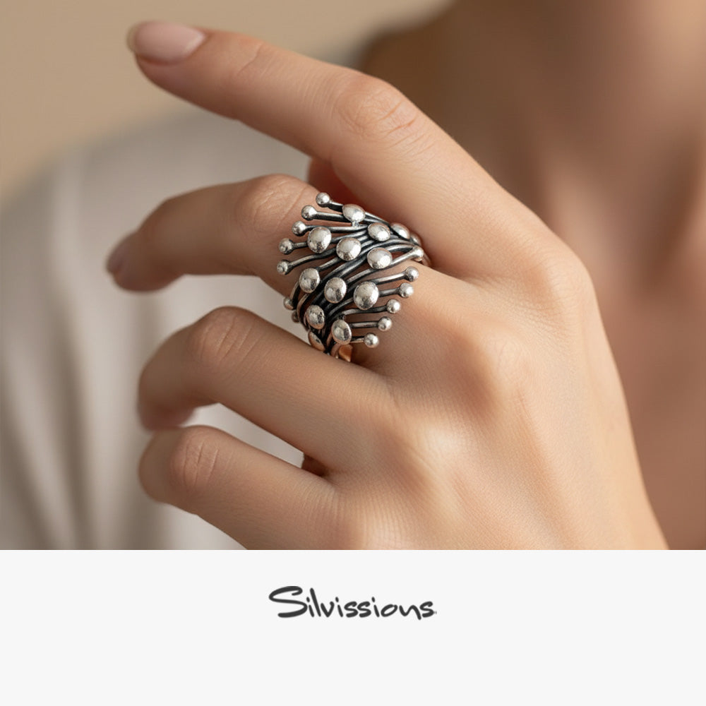 Silver ring on a hand with 'Silvissions' branding