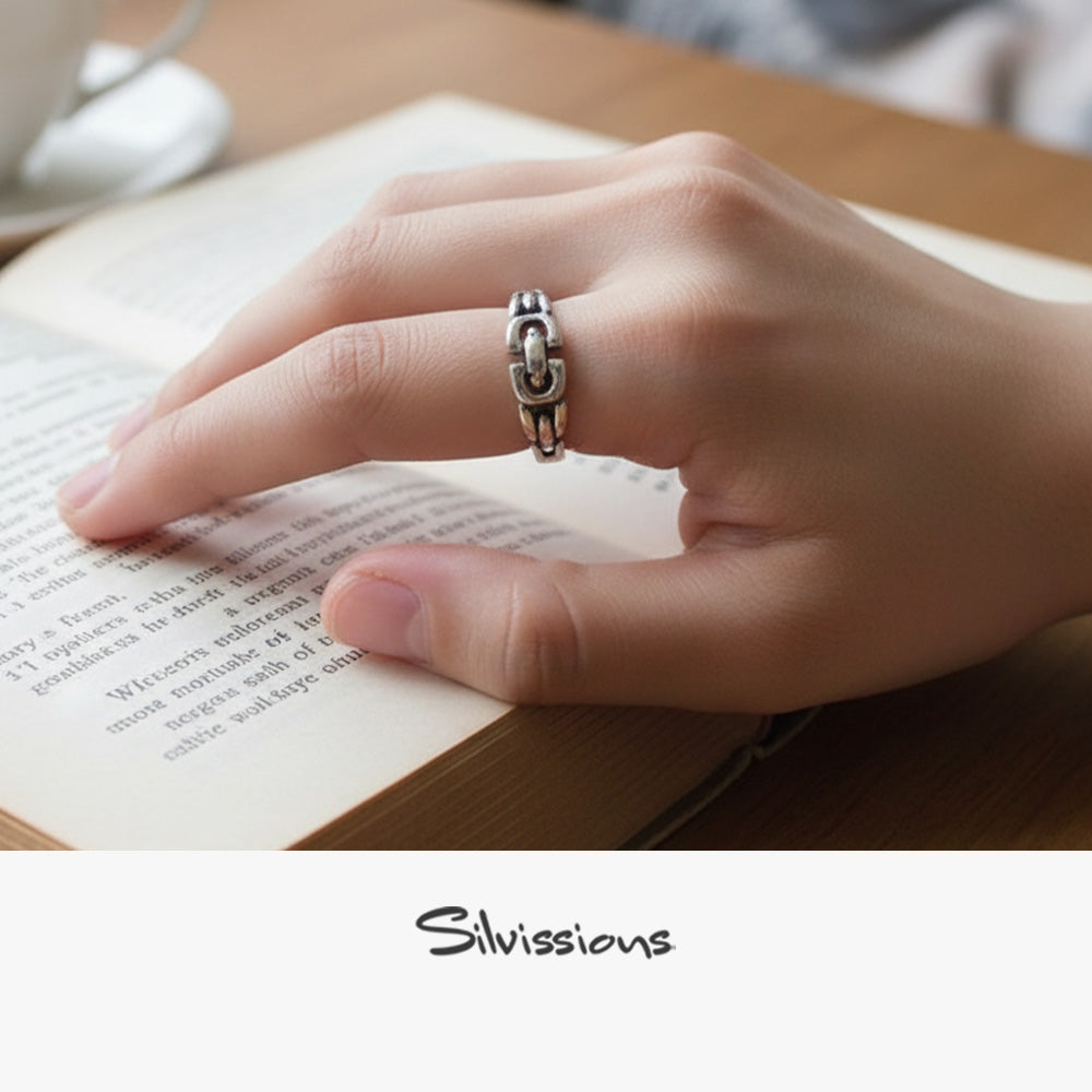 Hand wearing a silver ring on an open book with 'Silvissions' branding.