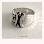 Silver ring with textured design on a light gray background, featuring the brand 'Silvissions'.