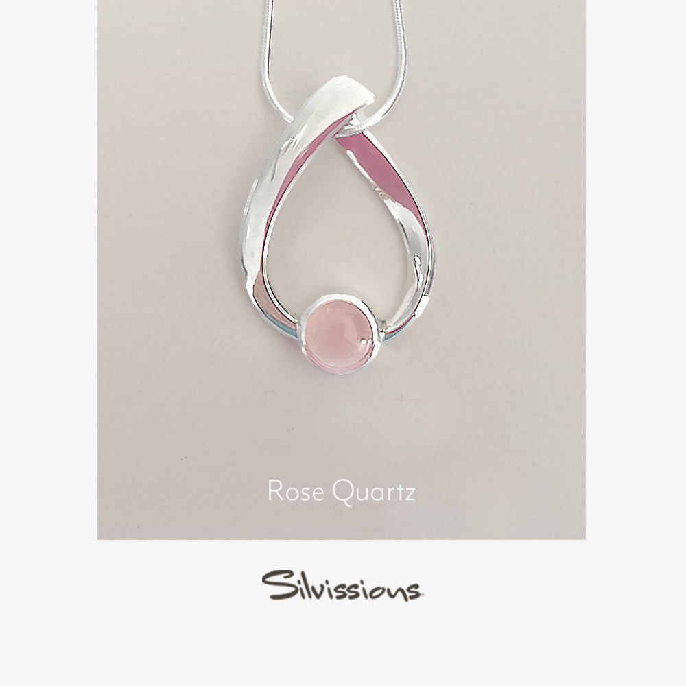 Silver necklace with a pink rose quartz pendant on a beige background, featuring the brand 'Silvissions'.