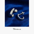 Silver earrings on a blue velvet background with 'Silvissions' branding.