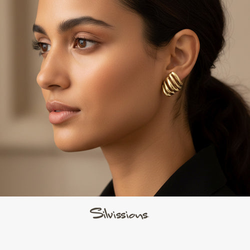 Close-up of a woman wearing silver stud earrings with 'Silvissions' branding.