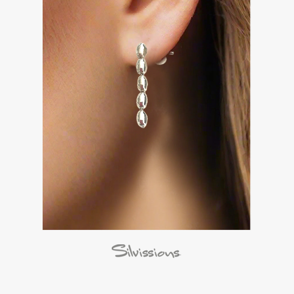 Silver earring worn on an ear with 'Silvissions' branding.