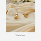 Sterling Silver and mixed metal stud earrings on a white fabric with 'Silvissions' branding.