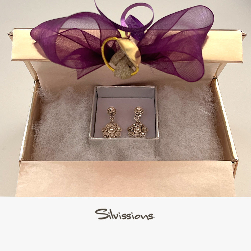 Sterling silver stud earrings in a handmade wrapped gift box with a purple bow, featuring the brand 'Silvissions'.