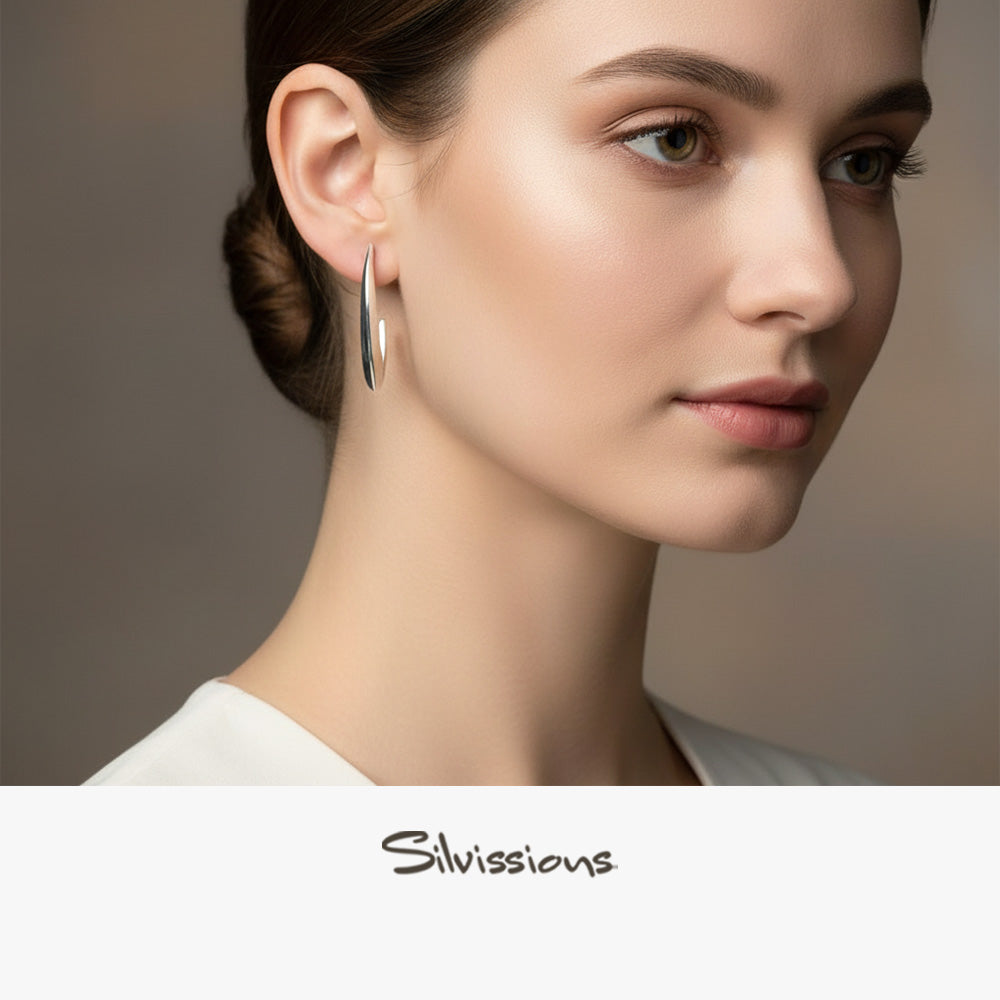 Close-up of a woman wearing stud earrings with 'Silvissions' branding.