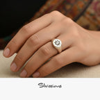 Hand wearing a silver ring with a sun design on a textured surface, featuring the brand 'Silvissions'.