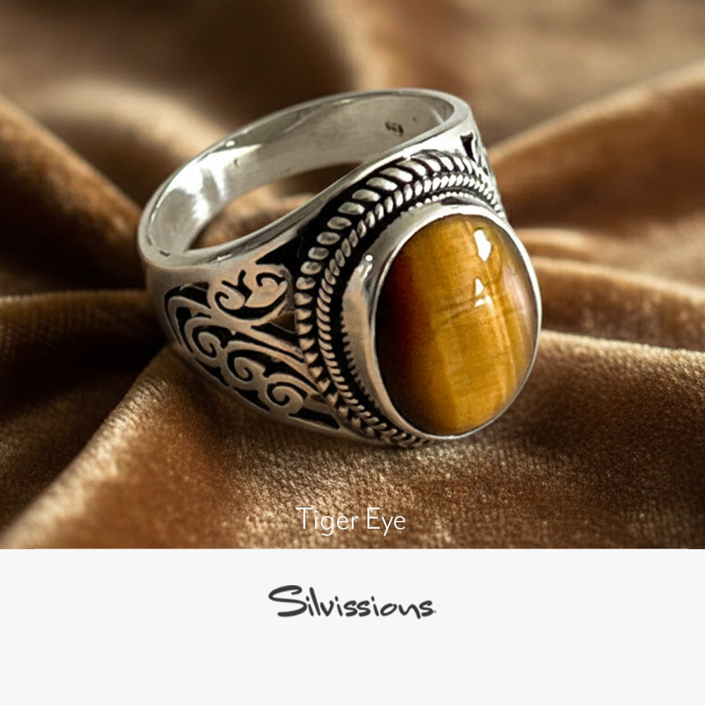 Silver ring with tiger eye stone on a wooden surface, branded 'Silvissions'.