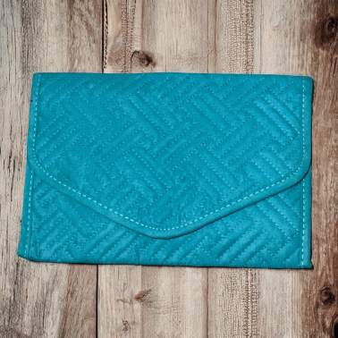 Blue textured travel jewelry organizer on a wooden surface