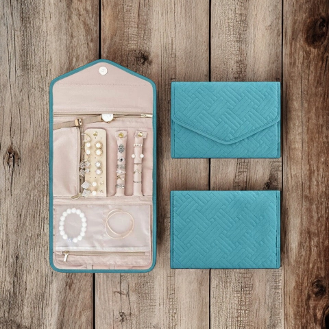 Teal jewelry case with jewelry and two teal pouches on a wooden surface