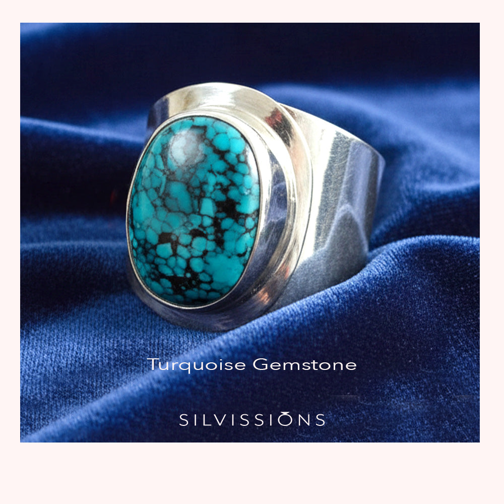 Silver ring with turquoise gemstone on blue fabric, featuring 'Silvissions' branding.