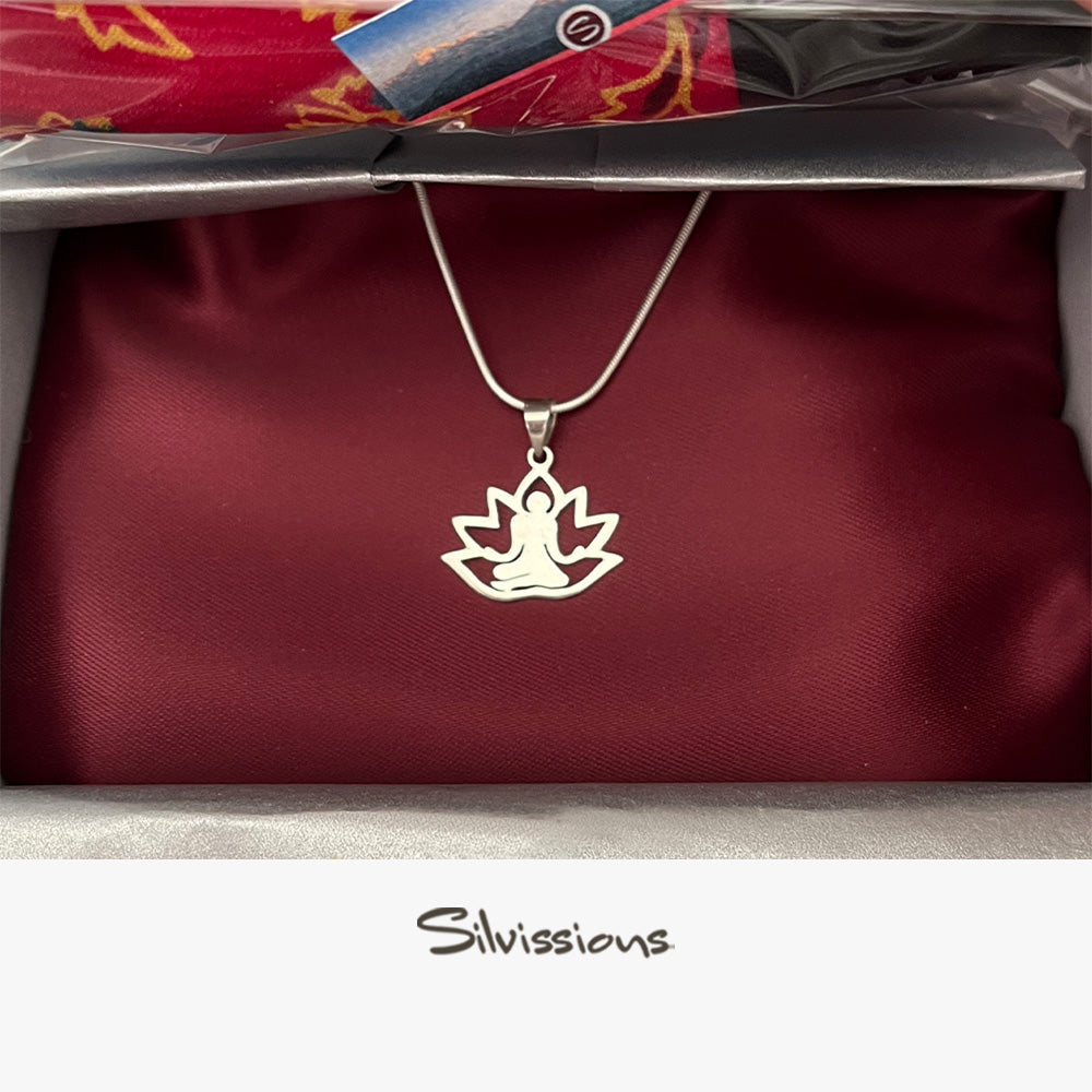 Silver pendant with a yoga design on a red satin background, branded 'Silvissions'.